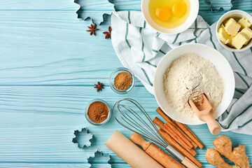 Baking background with ingredients for making gingerbread flour, eggs, kitchen tools, utensils and cookie molds on blue wooden table. Top view. Flat lay style. Mock up. Christmas baking.