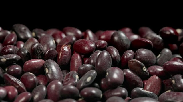 Close-up of red bean seeds on a black background. slider motion, red beans abstract.