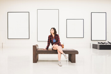 A young woman sits at a festival displaying art in an art gallery. Take a walk around the art...