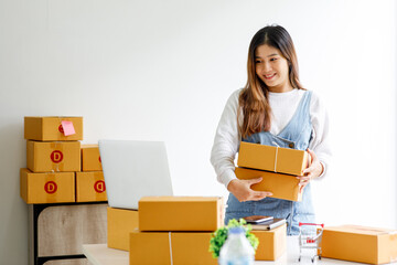 Portrait of businesswoman start small business and successful SME entrepreneurs A female works from home delivering parcels online ideas SME delivery and packaging concept.