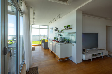 Obraz premium Modern kitchen interior in luxury studio apartment. Panorama windows.