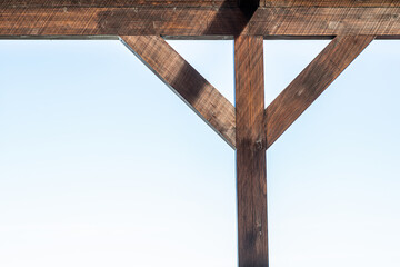 Close-up of wooden support of roof with sky on background