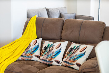 Cozy grey couch with cushions and yellow plaid.
