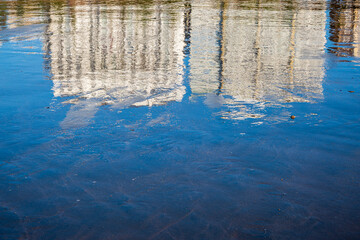 Buildings and sky reflected on a wet beach