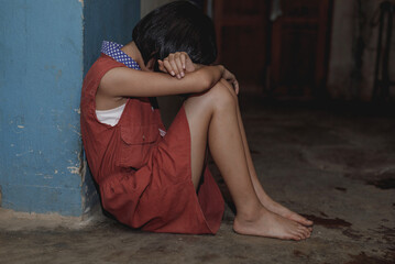 Little girl covered her face sitting alone on floor in dark room. concept for bullying, depression...