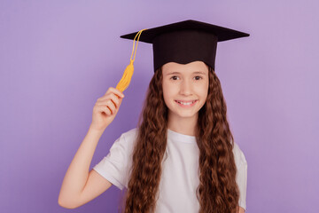 Portrait of pretty positive cheerful girl wear student hat hold pompom toothy smile on purple background