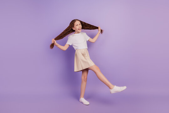 Portrait of funky positive careless girl hold tails dance party on purple background
