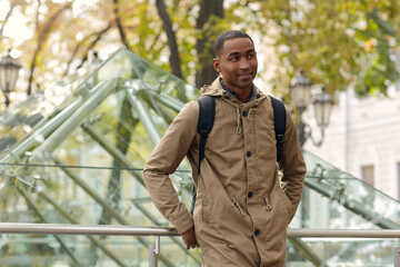 Smiling black male student standing in city