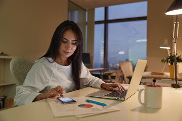 Businesswoman working with mobile phone and laptop