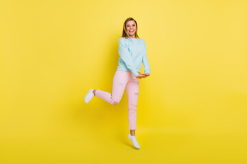 Fototapeta na wymiar Full length body size view of attractive carefree cheerful girl jumping good mood isolated over bright yellow color background