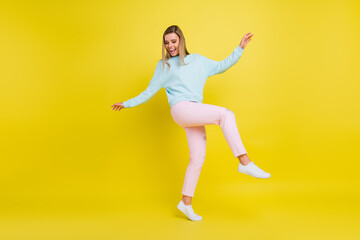 Fototapeta na wymiar Full length body size view of attractive carefree cheerful girl moving having fun isolated over bright yellow color background