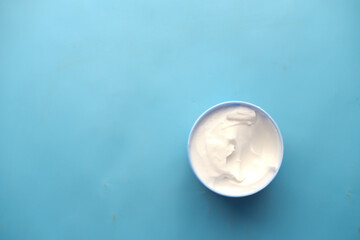 f beauty cream in a container on blue background 