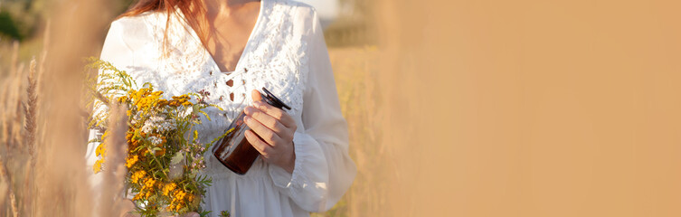 Concept medicinal herb herbalist. BANNER, copy-space. Woman picking herbs against the backdrop of a...