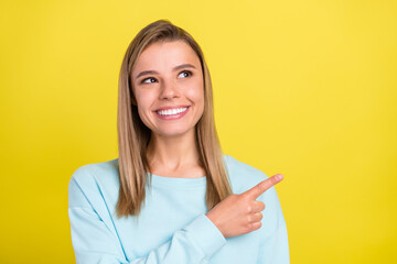Portrait of attractive cheerful girl demonstrating new copy blank place space isolated over bright yellow color background