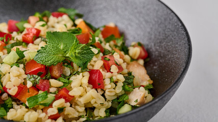Macro Middle Eastern traditional salad tabbouleh made of bulgur or couscous. Selective focus
