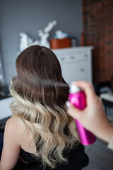 Fototapeta premium stylist hairdresser makes a hairstyle for a girl in his beauty salon, hollywood wave, beautiful hairstyle, hairdresser at work