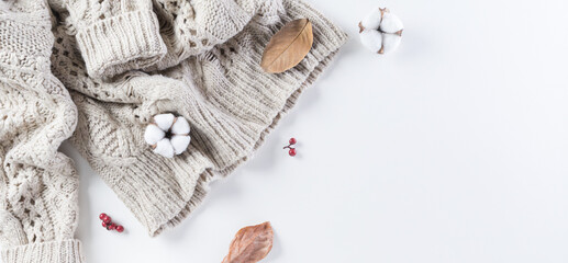 Fototapeta na wymiar Autumn composition. Cotton flowers, autumn leaves and women sweater on white background. Flat lay, top view with copy space.