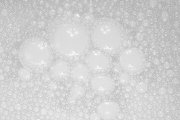 Texture of small soap bubbles on water background. foam