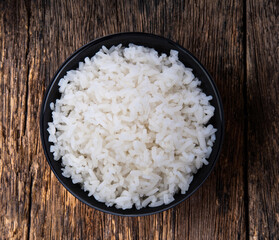 rice in black bowl on wood