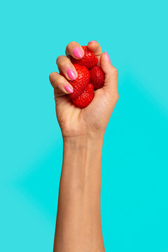 Hand holding strawberries