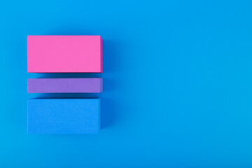 Flat lay with bisexual pride flag made of colorful blocks on blue background. Concept of lgbtq plus community, Pride month, sexual minorities and tolerance - obrazy, fototapety, plakaty