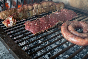 Process of preparing a typical Argentinian Asado with beef and sausage - obrazy, fototapety, plakaty