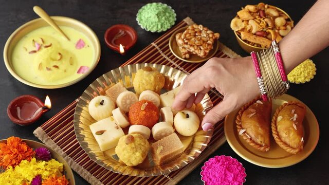 Indian woman taking Diwali sweets Gujiya peda barfi Indian sweet dessert mithai festival Dussehra Holi ganesh chaturthi Ram navami Durga pooja ashtami Navratri 4K footage Mumbai Kerala India Sri Lanka
