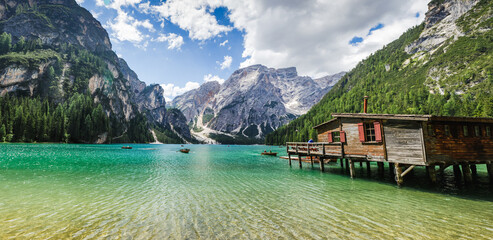 Lago di Braies in Dolomites, mountains forest trail in background, Sudtirol, Italy