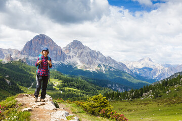 Naklejka na ściany i meble Woman traveler with breathtaking landscape of Dolomites Mounatains in summer, Italy. Travel Lifestyle wanderlust adventure concept