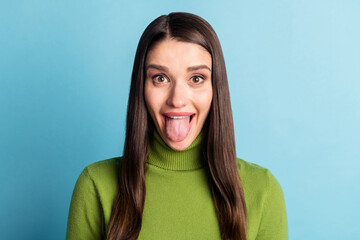 Portrait of attractive cheerful funky girl showing tongue out fooling isolated over bright blue color background © deagreez