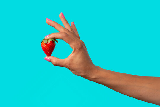 Hand holding strawberry