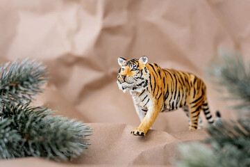 Tiger symbol of the Chinese new year 2022. Figurine of tiger with branches spruce tree on pastel background. Copy space.
