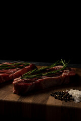 Raw marbled beef steak on a wooden cutting board. Top class marbled beef. Graphite-colored table top.