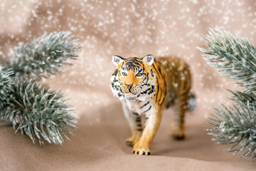 Tiger symbol of the Chinese new year 2022. Figurine of tiger with branches spruce tree on pastel background. Copy space.