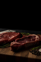 Raw marbled beef steak on a wooden cutting board. Top class marbled beef. Graphite-colored table top.