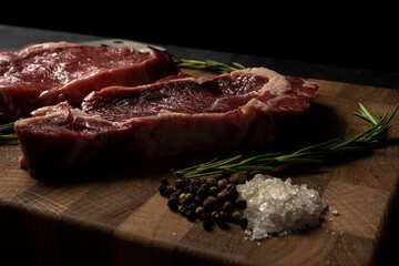 Raw marbled beef steak on a wooden cutting board. Top class marbled beef. Graphite-colored table top.
