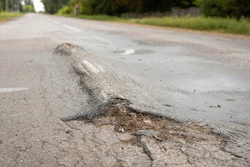 Road in terrible condition due to ignoring weight limit and driving very heavy truks. Asphalt road...