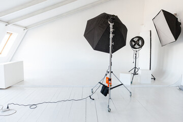 Empty photo studio with lighting equipment. Photographer workplace interior with professional tool set gear. Flash light white background scenes ready for studio shooting. Modern photographer studio