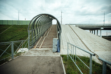 aboveground pedestrian crossing. stairs for people to cross over railway tracks. engineering structure for pedestrian safety. metal ramp for the disabled