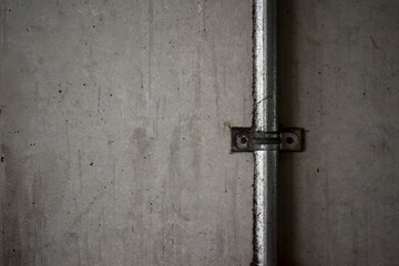 コンクリートの外壁と汚れた金属の配管