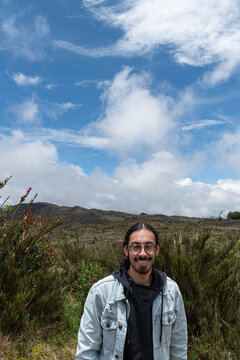 1 hombre con pelo largo en la naturaleza sonriendo mientras mira la c&aacute;mara 