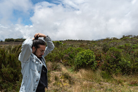 1 hombre con pelo largo en la naturaleza peinando su pelo 