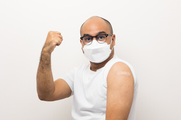 Young asian man wearing mask received a corona vaccine. Portrait of Asian man show shoulder with...