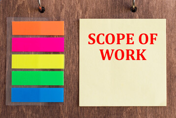 SCOPE OF WORK text on yellow card on wooden background