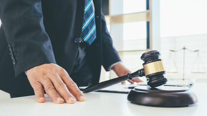 Judge gavel with Justice lawyers having team meeting at law firm background. Concepts of Law and Legal services.