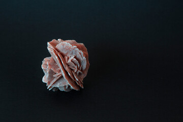 Desert rose crystal closeup photography on black background with copyspace