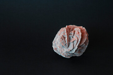 Desert rose crystal closeup photography on black background with copyspace