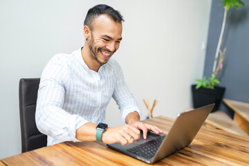 Portrait young mexican attractive businessman working at modern home office with computer laptop