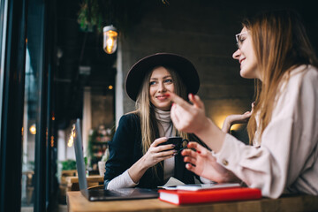 Smiling women discussing at table of bar