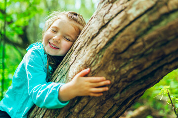 little girl on tree in the summer on nature little girl